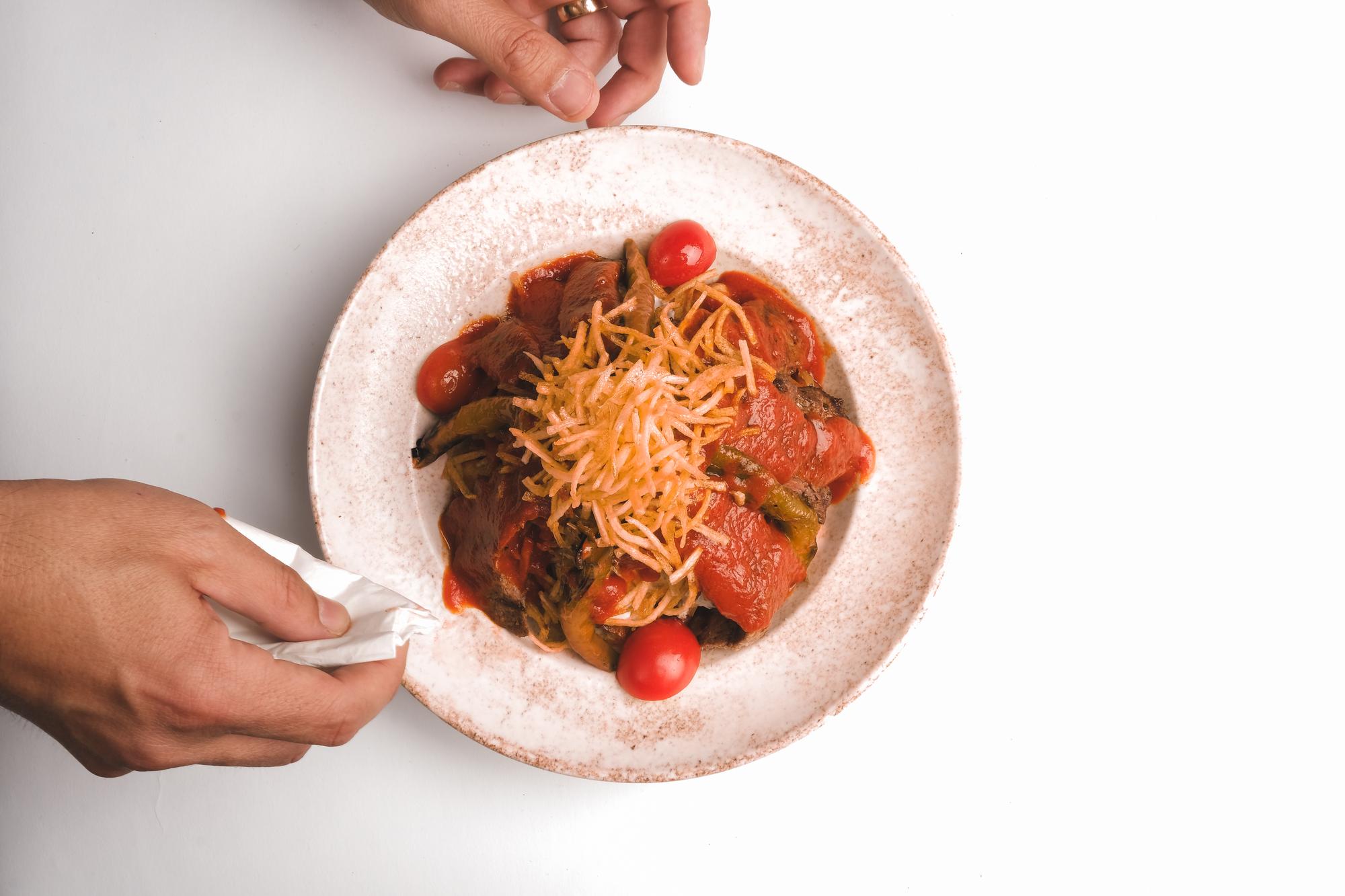 Chef locale che impiatta un piatto rustico